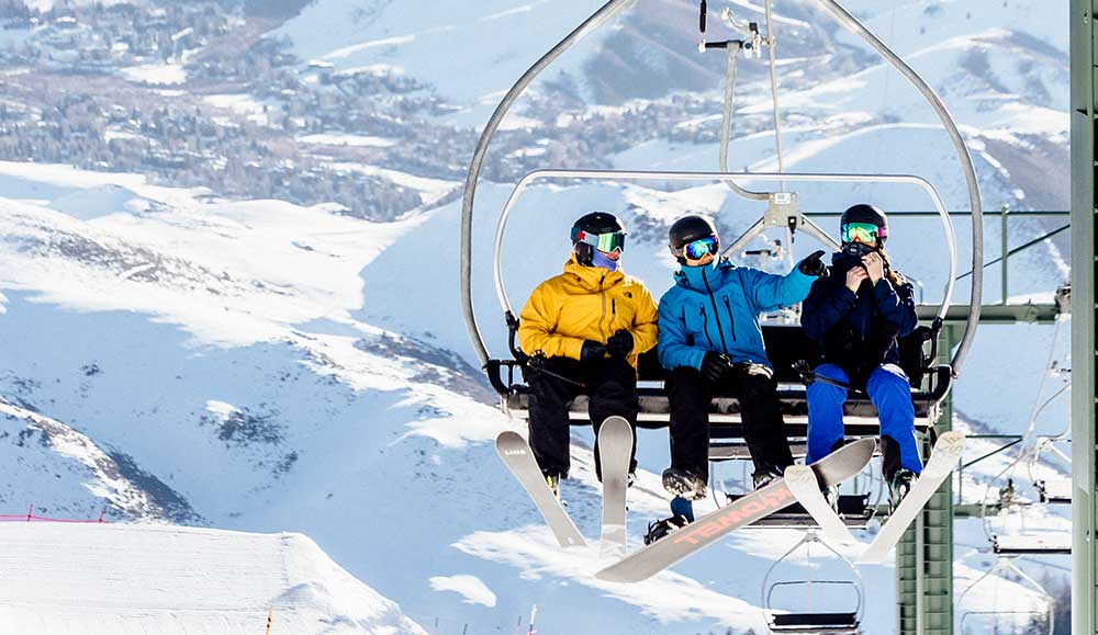 Three friends ride up the lift at Sun Valley.