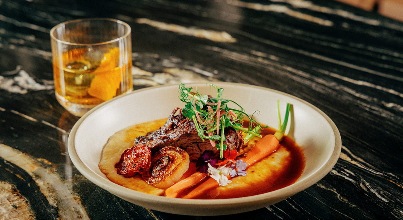 close up of food dish and cocktail on table