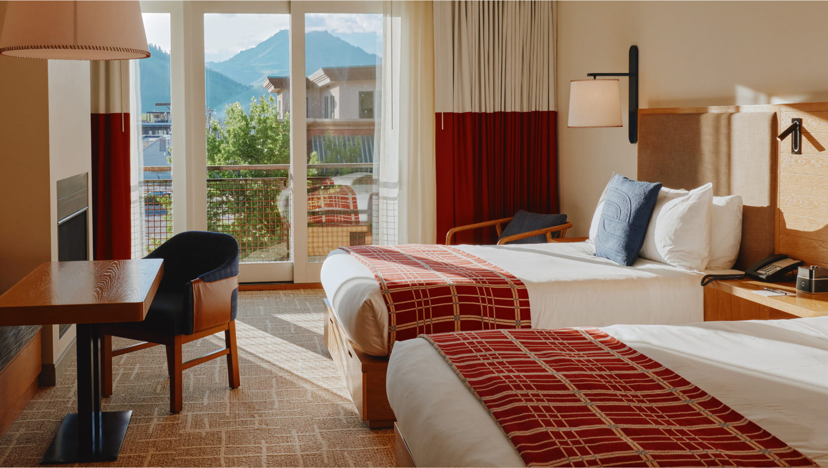 two queen beds and table in guest room