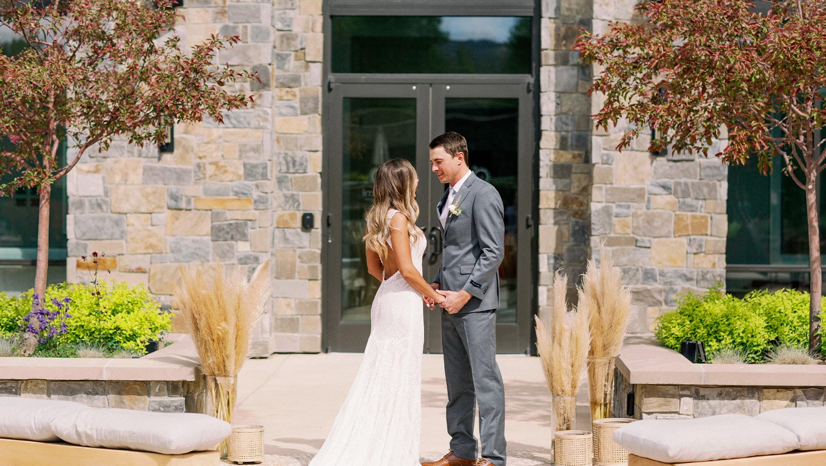 A bride and groom stand facing each other holding hands at their wedding at Limelight Hotel in Ketchum, Idaho.