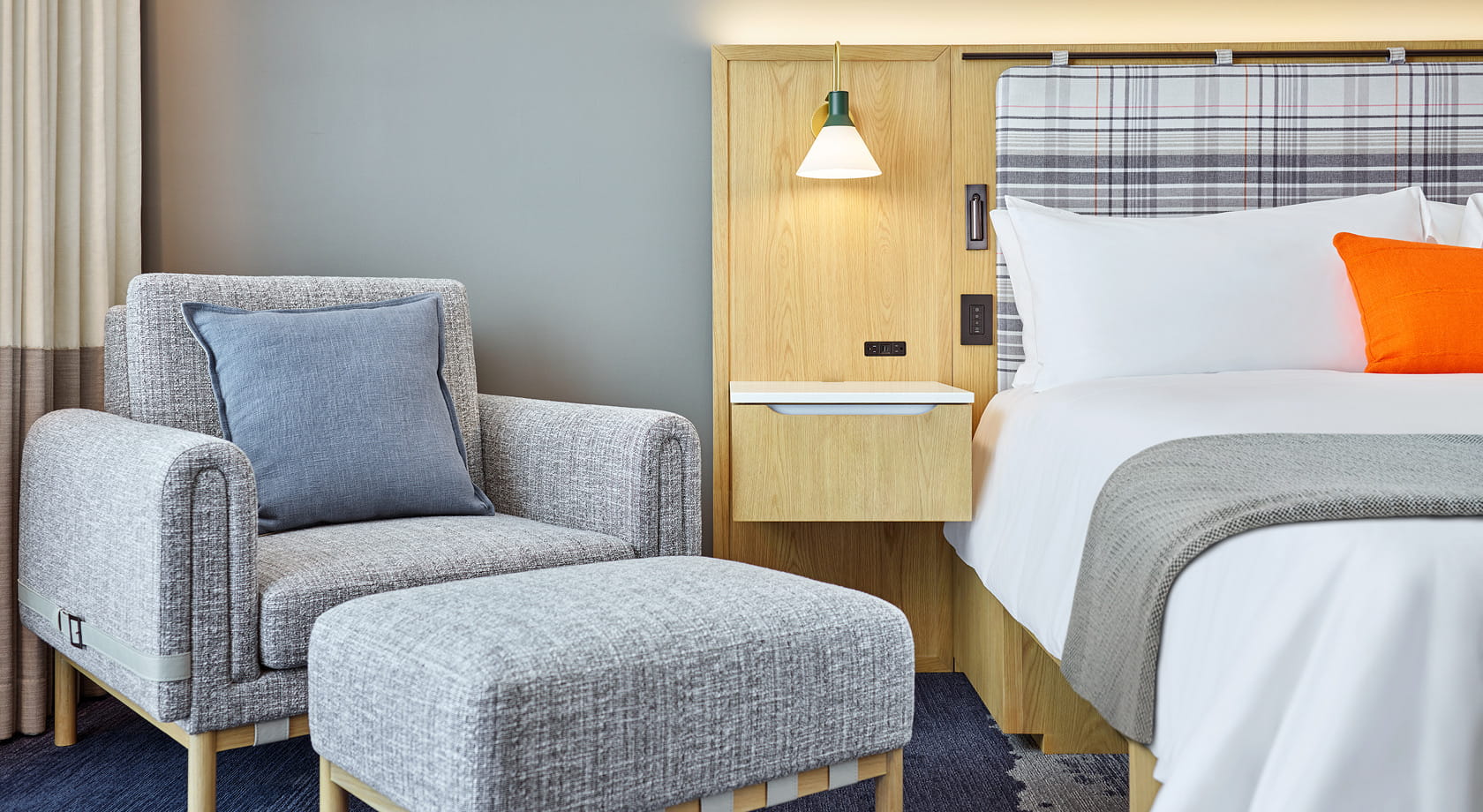side of bed and chair in guest room
