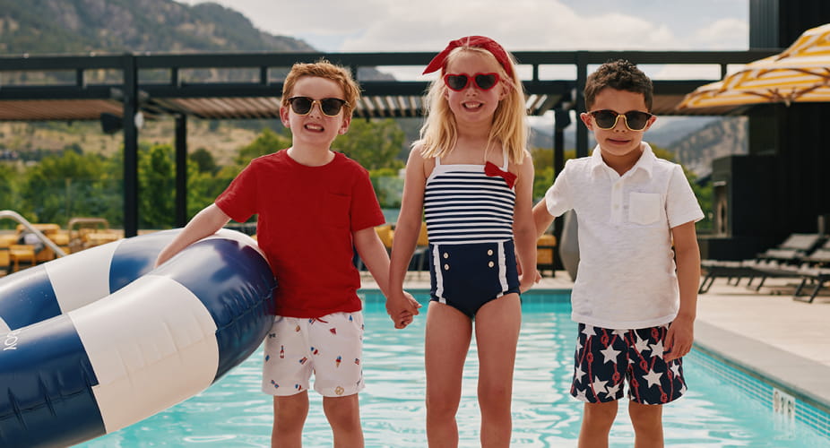 three kids in front of pool