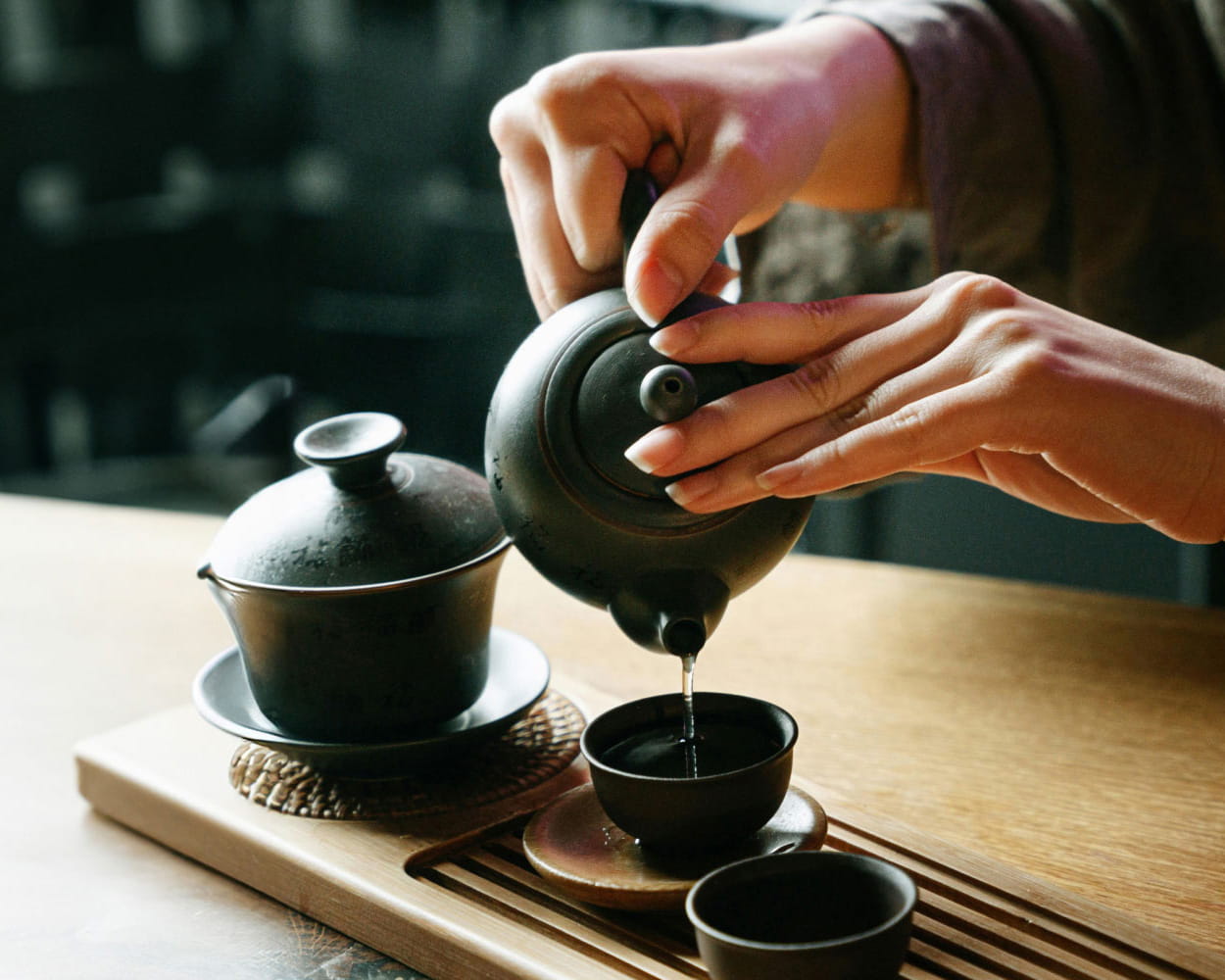 woman pouring tea into cup
