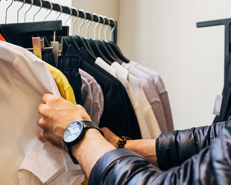 man looking through clothing in store