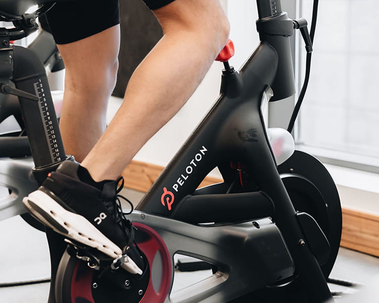 man using peloton bike