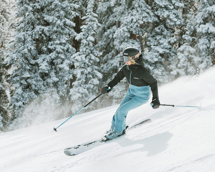 female skier skiing down mountain