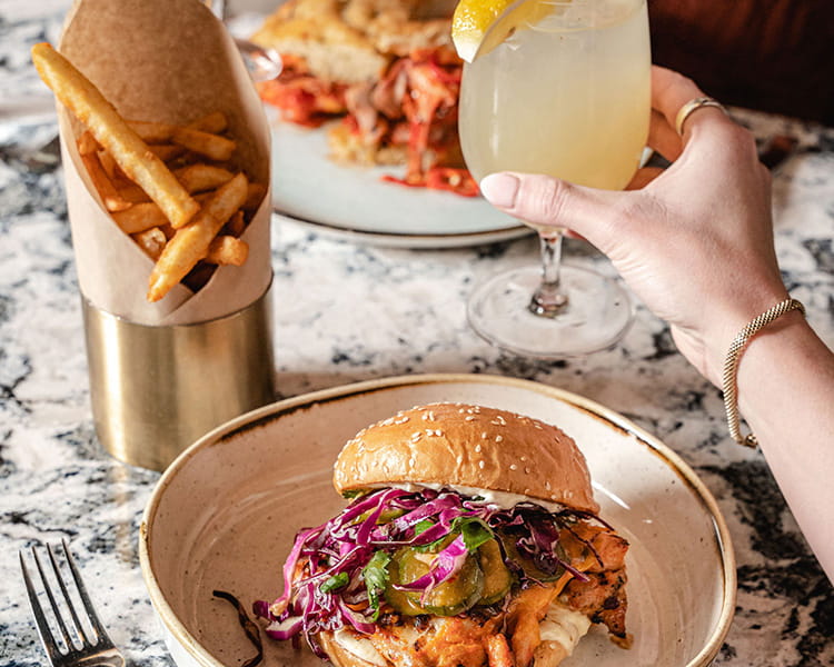 ajax sandwich, fries, and cocktail on table