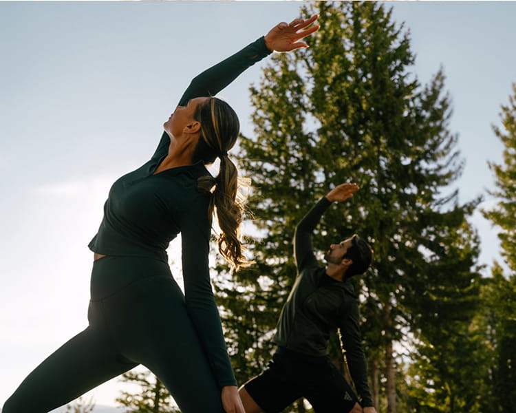 two people doing yoga outside