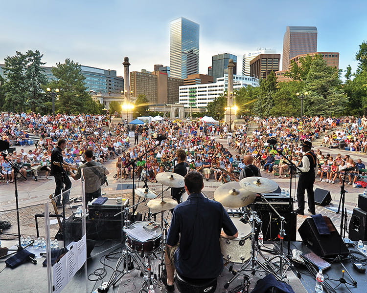 concert in civic center with denver skyline