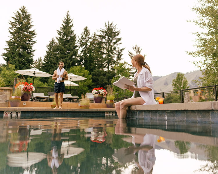person reading book in pool outside