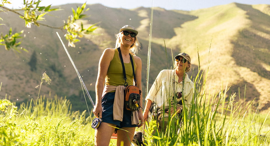 two people fly fishing in mountains