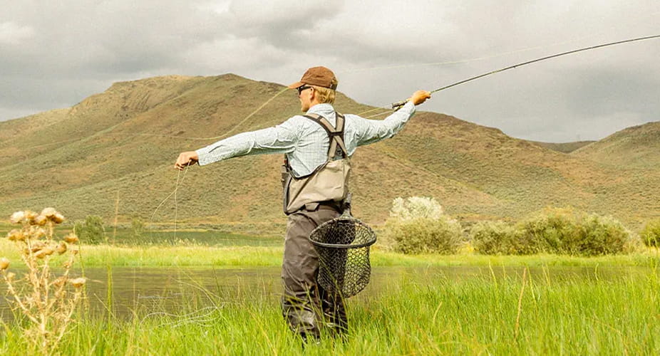 man fly fishing in the mountains