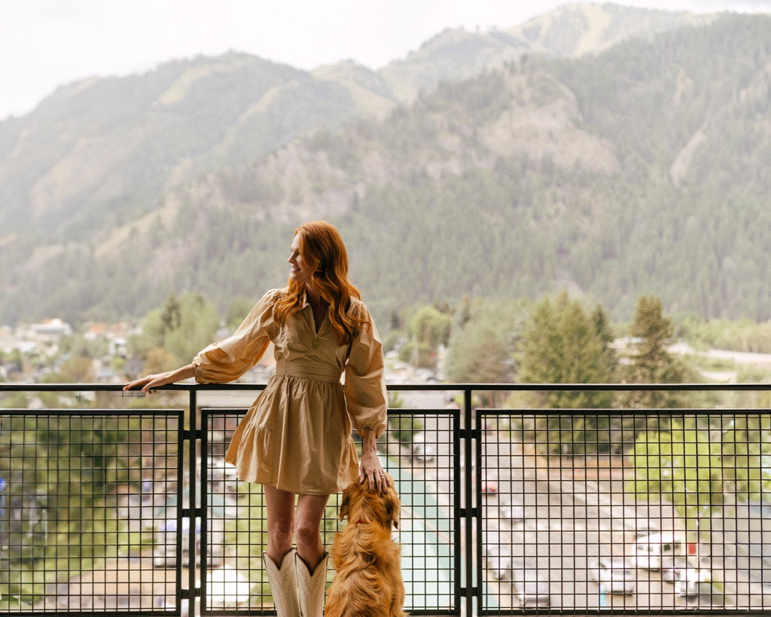 woman with dog on guest room balcony