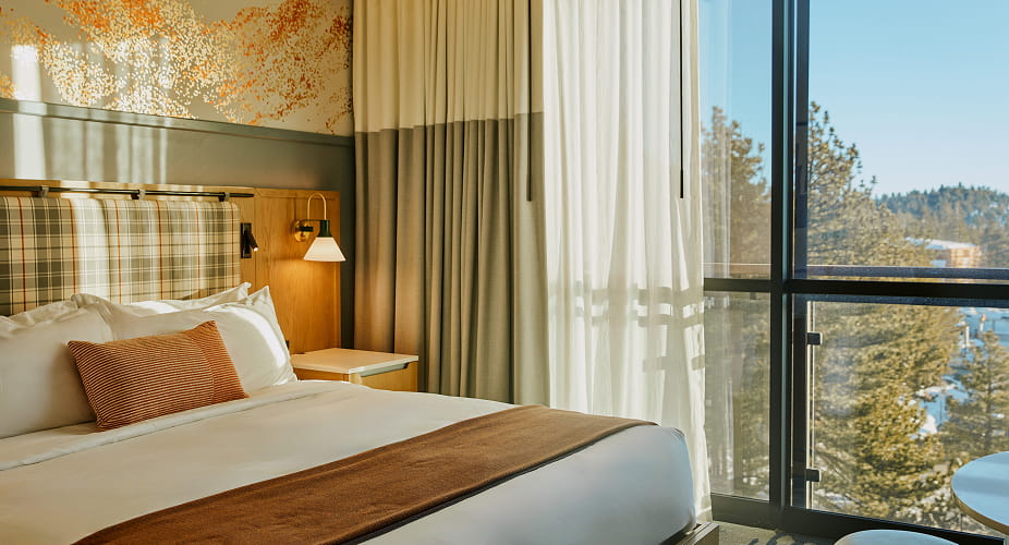 bed in guest room overlooking mountains