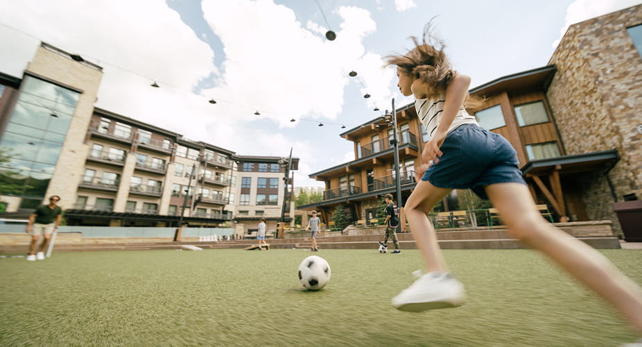 little girl playing soccer in base village