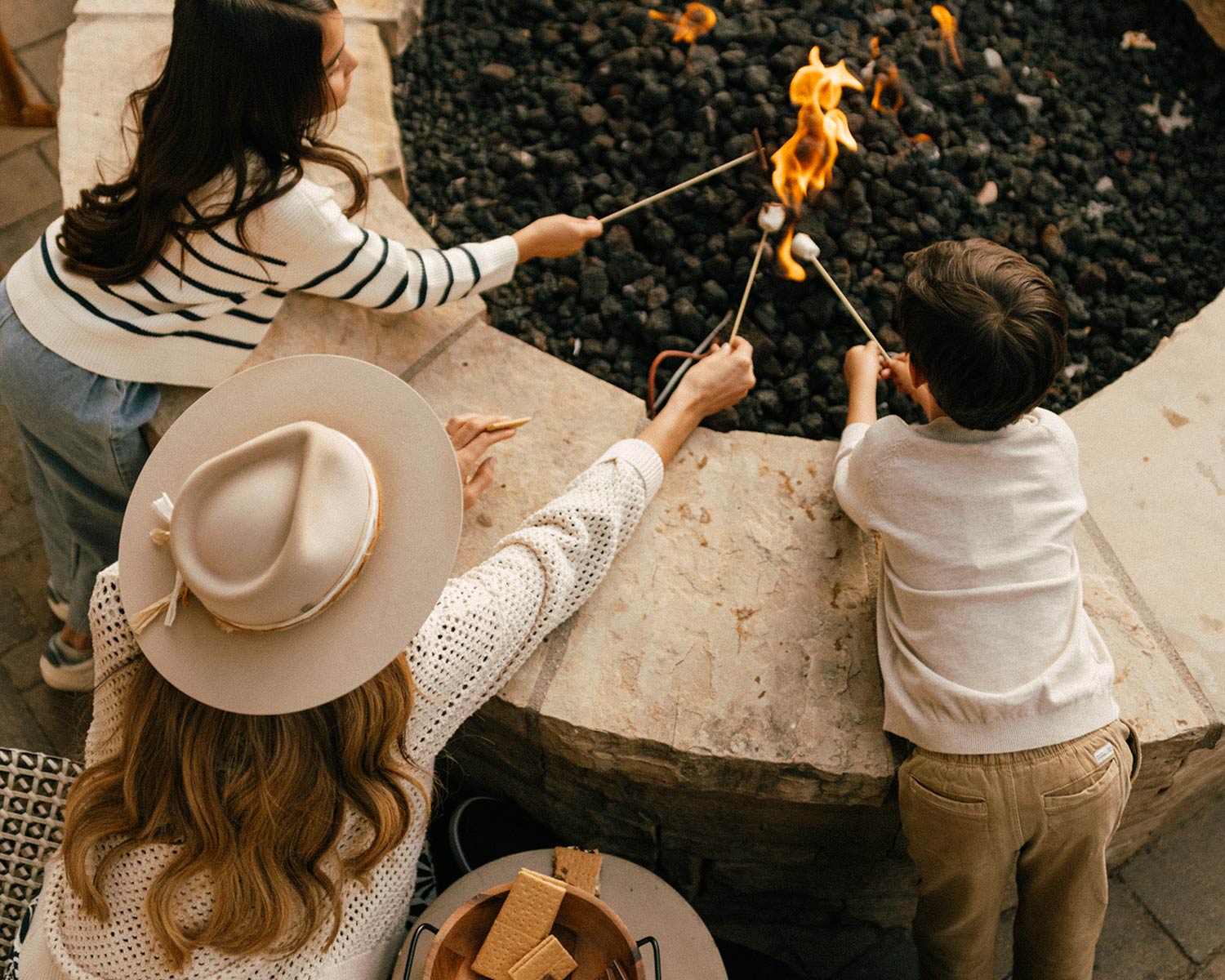 family roasting marshmallows outside 