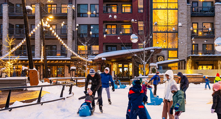 people skating on ice rink in front of limelight snowmass