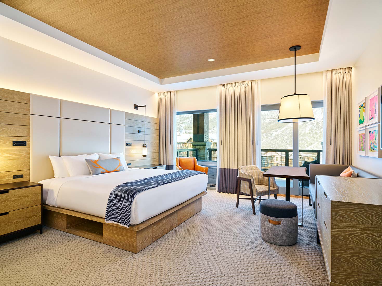 A cozy bedroom at Limelight Hotel in Snowmass, Colorado. This room features a seating area and fireplace.