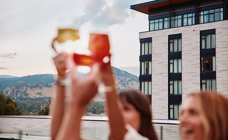 friends cheerings drinks on hotel rooftop