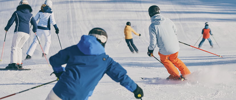 skiiers skiing down mountain
