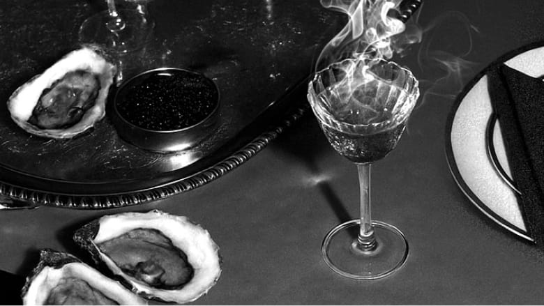 cocktail and oysters on table