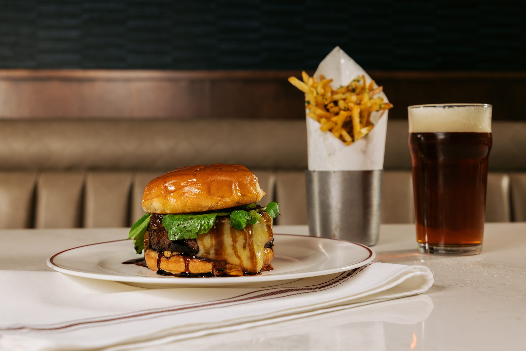 A burger, fries and beer on a restaurant table