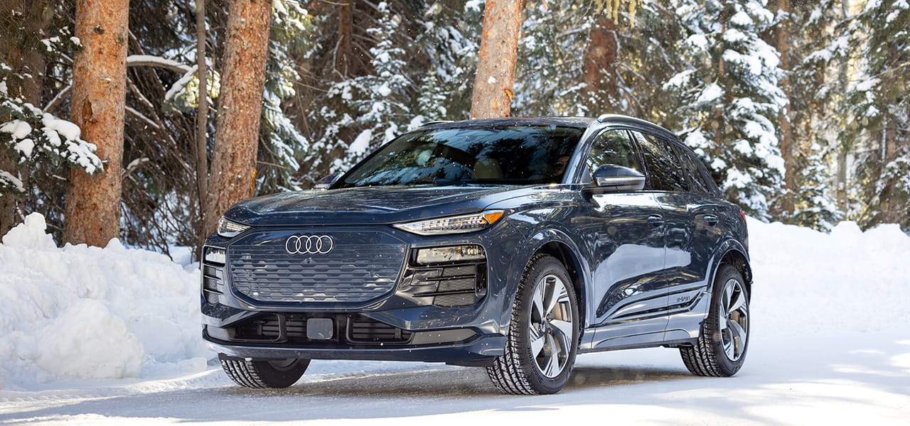 Navy blue Audi car driving on a snowy road