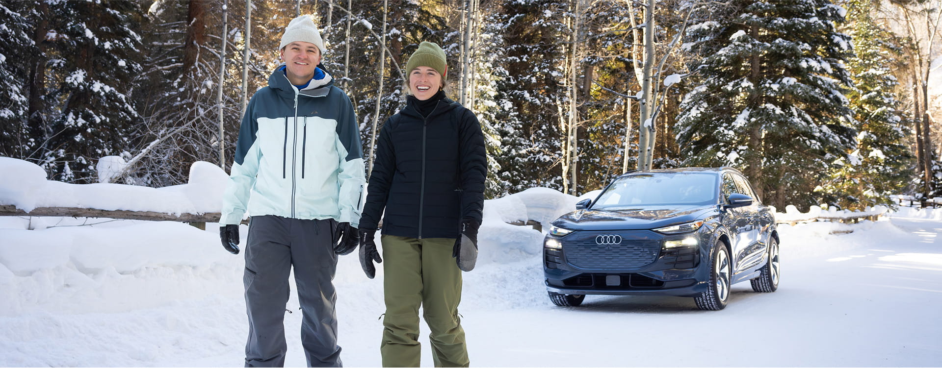 couple snowshoeing near audi car