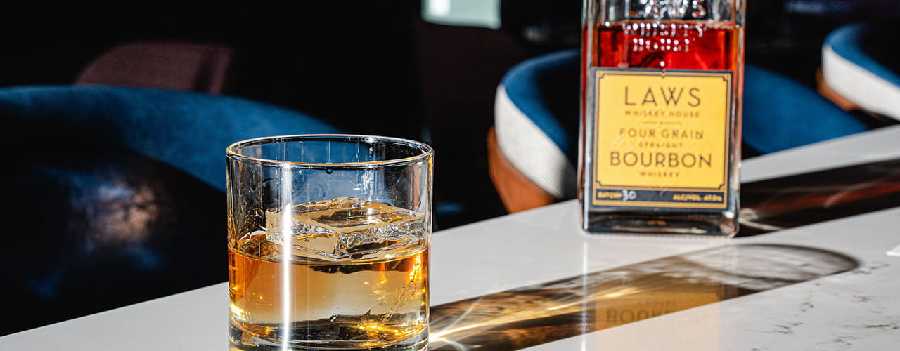 laws whiskey bottle and glass on bar