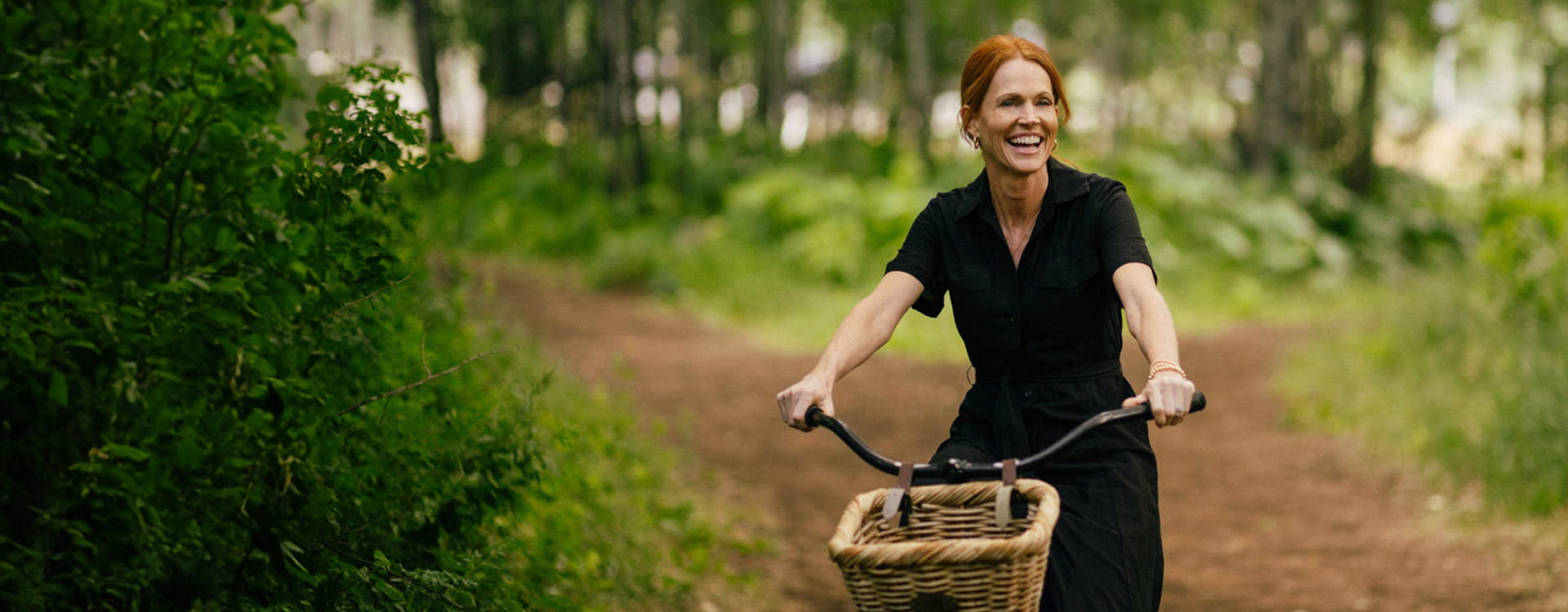 woman biking through forest