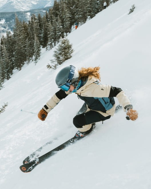 Skier in cream and black outfit on a mountain slope