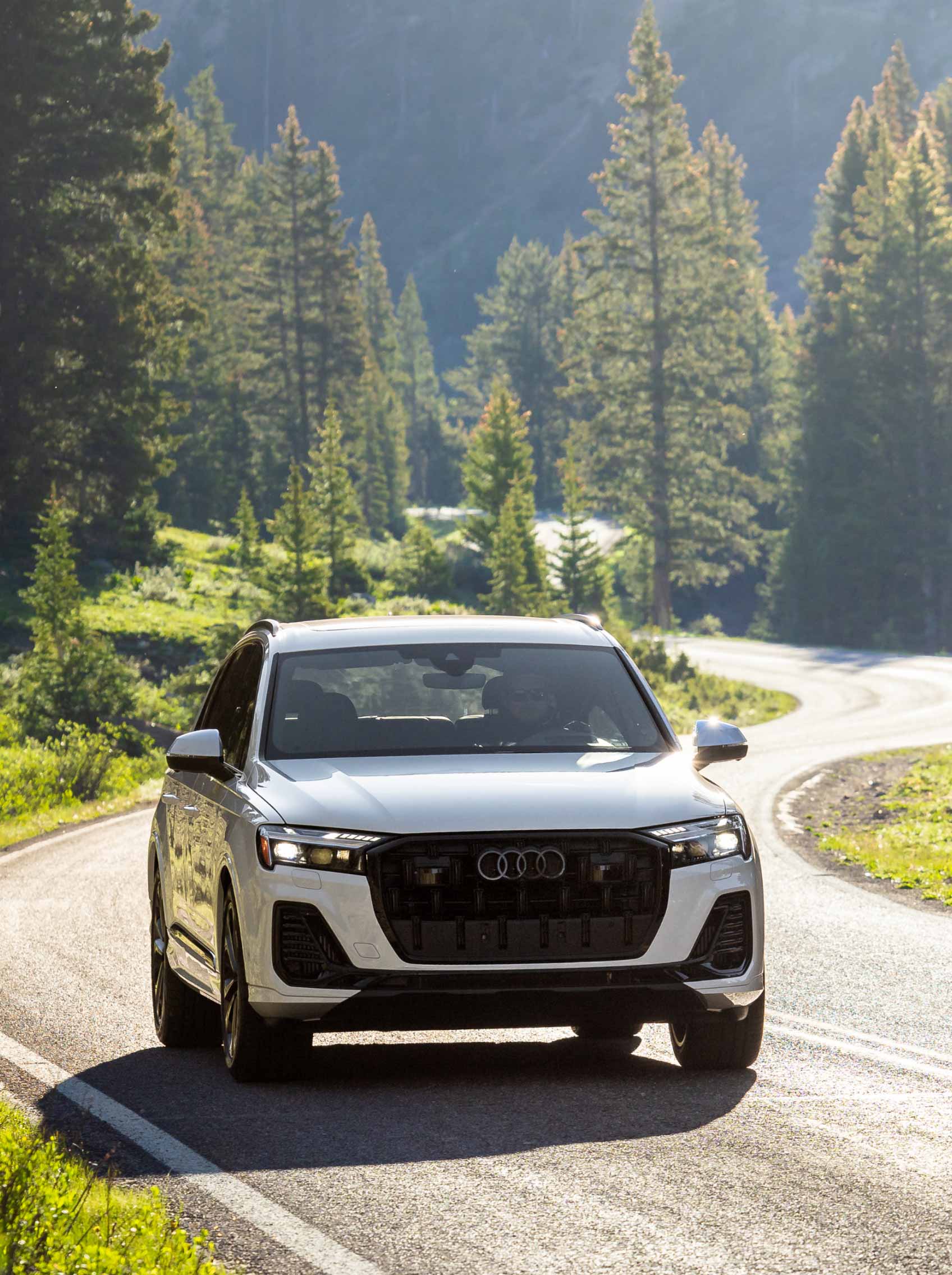 audi car driving on road in front of mountains