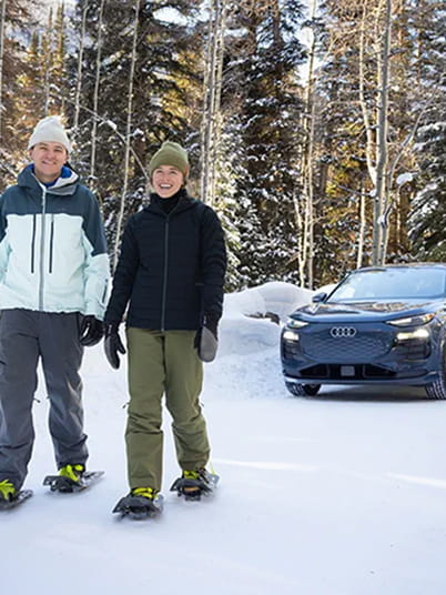 couple in front of audi suv