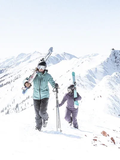 two skiers hiking up Aspen Highlands