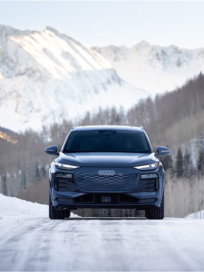 audi car driving on road in front of mountains