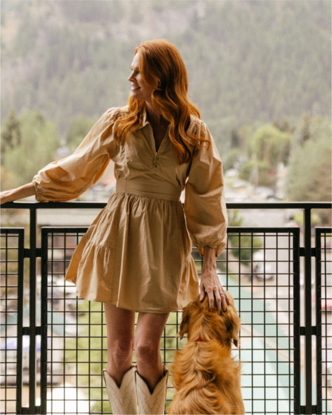 woman with dog on guest room balcony