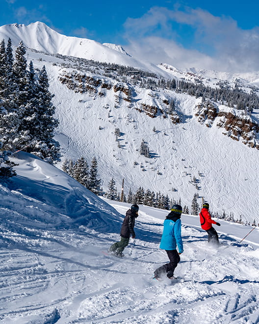 instructor and two snowboarders at snowboard lesson