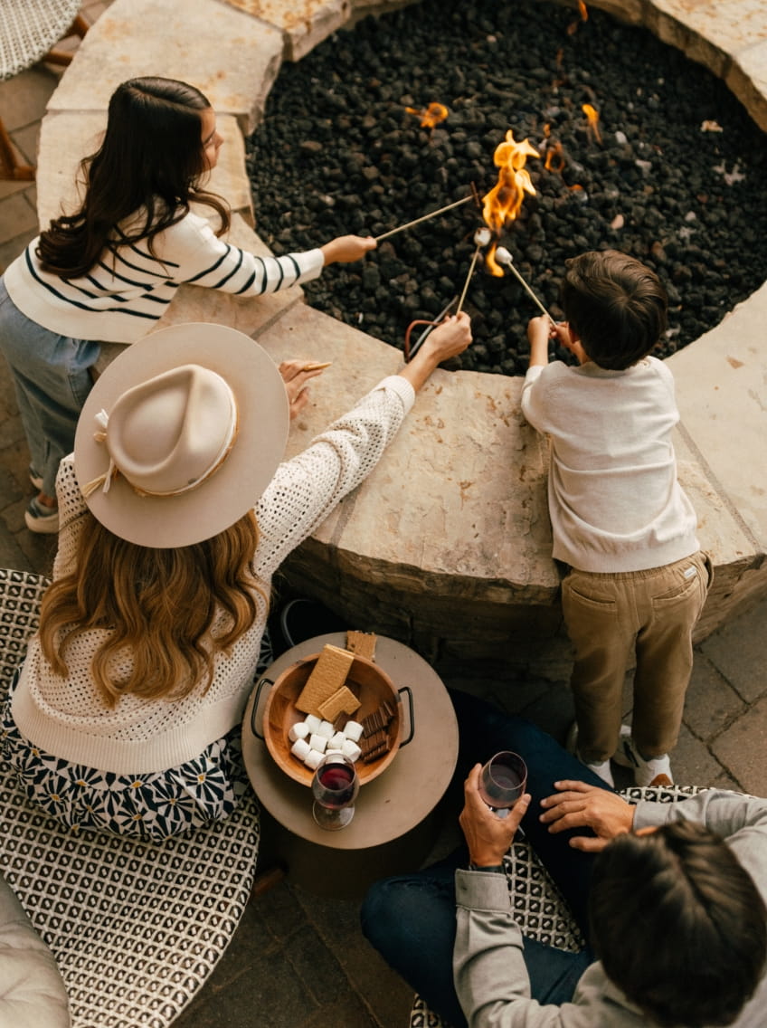 family roasting marshmallows outside 