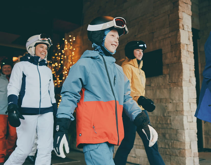 family of skiers walking out of hotel