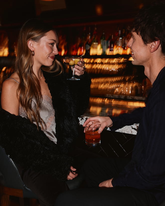 two people at bar drinking