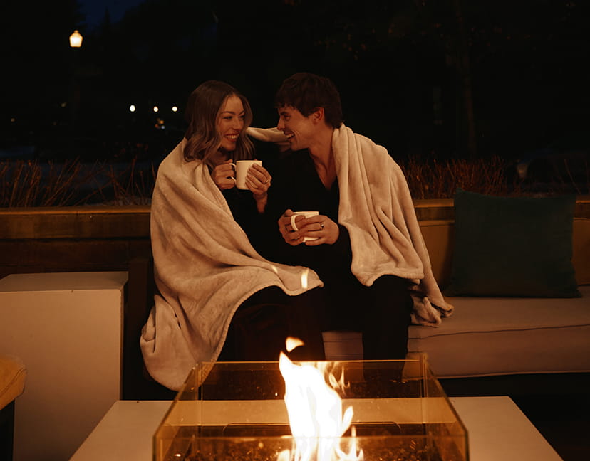 couple by fire laughing