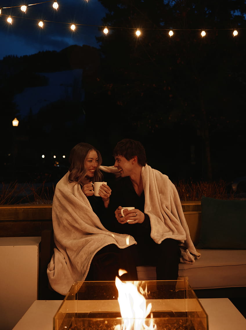 couple by fire laughing