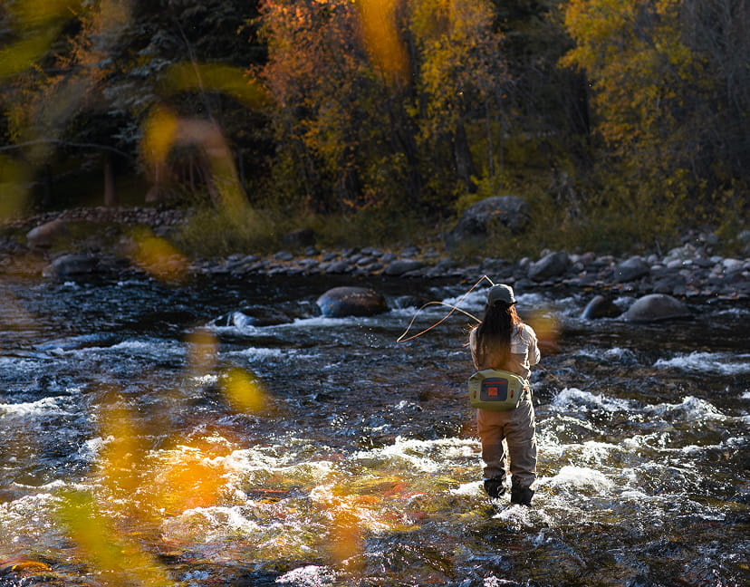 woman fly fishing in the fall
