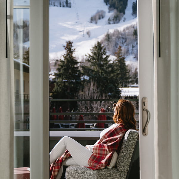woman on balcony at limelight aspen overlooking aspen mountain