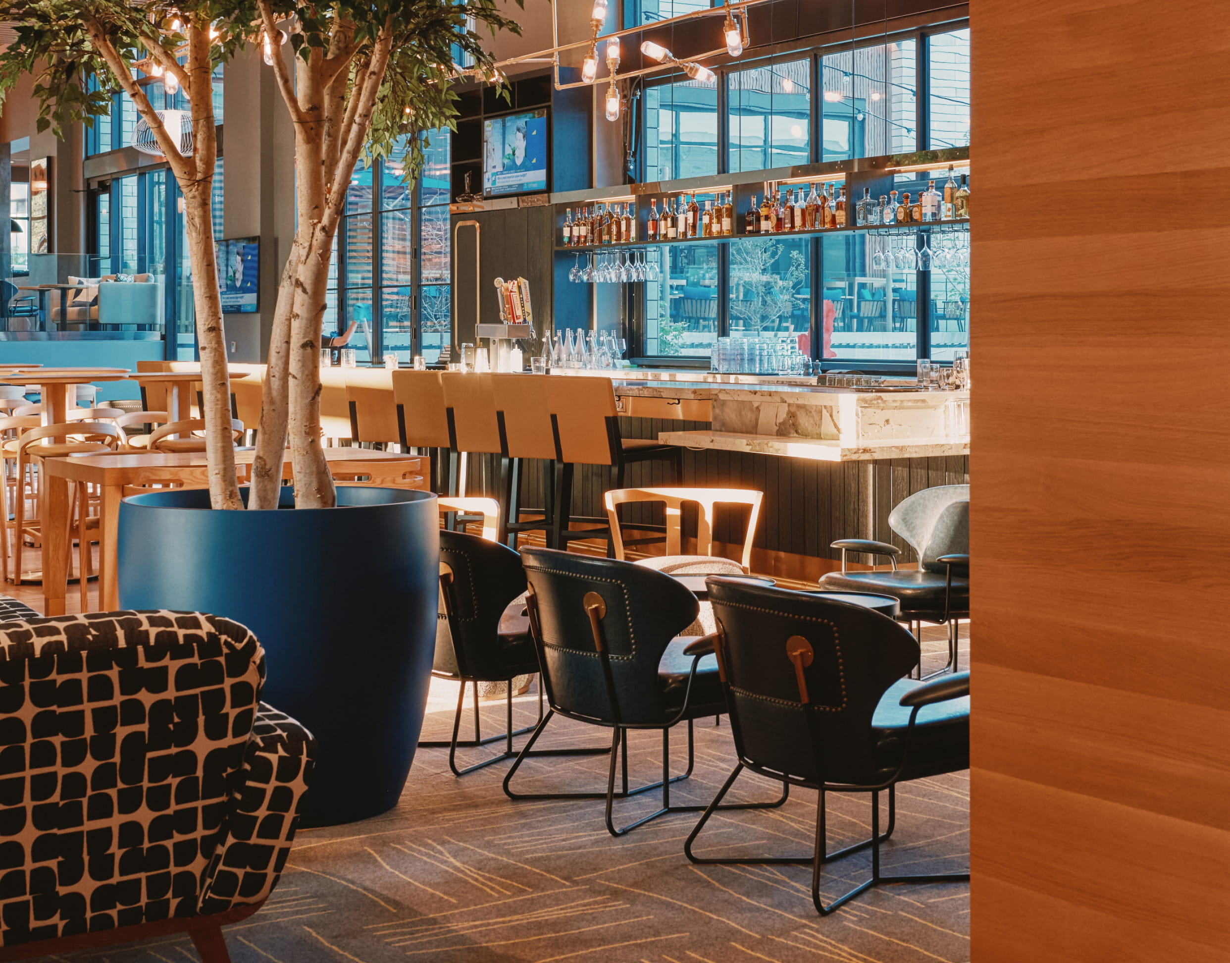 Inside of a hotel lobby bar with a large indoor plant