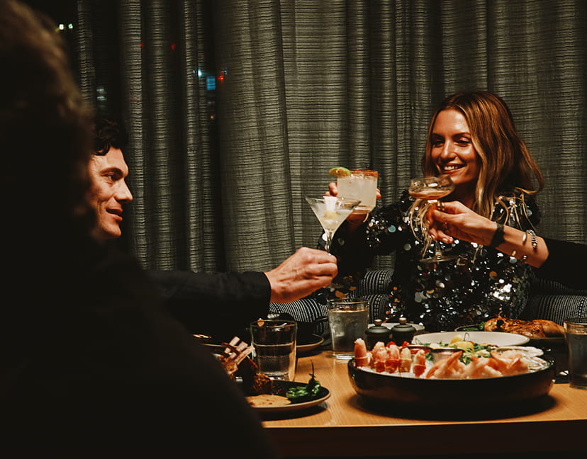 friends cheerings drinks at table in ajax tavern