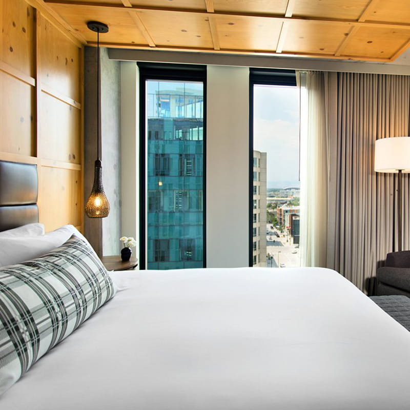 king bed in guest room overlooking denver and mountains