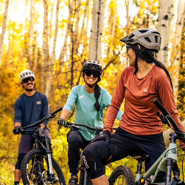 three people mountain biking in the fall aspens