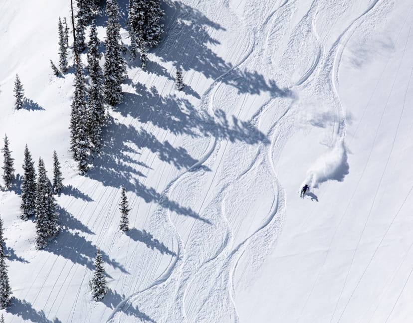 Skier creating lines in the powder on a ski mountain