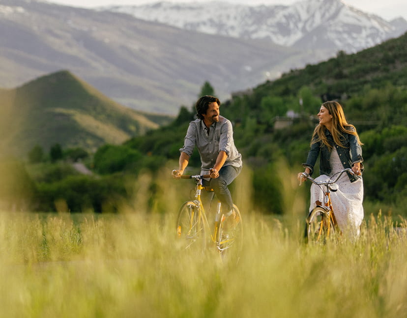 two people biking through snowmass mountains